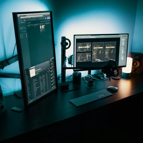 pexels-photo-1714208-1714208 A contemporary office desk featuring a dual monitor setup with stylish lighting, ideal for tech enthusiasts.