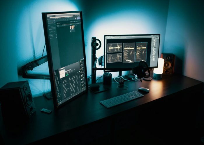 pexels-photo-1714208-1714208 A contemporary office desk featuring a dual monitor setup with stylish lighting, ideal for tech enthusiasts.