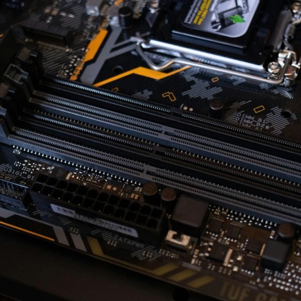 pexels-photo-2582932-2582932 Detailed view of a computer motherboard showcasing RAM slots and electronic components.