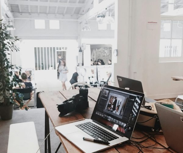pexels-photo-699459-699459 A bright, modern workspace featuring laptops, a camera, and a drawing tablet in an indoor office.